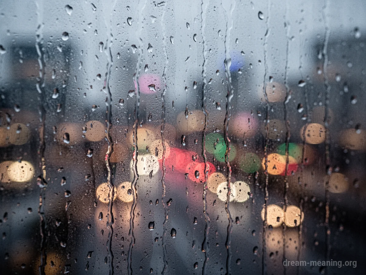 Blurred city lights viewed through a window with raindrops.