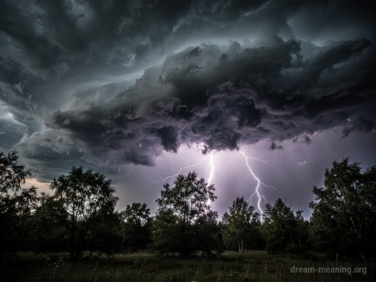 Dark storm clouds with lightning over trees.
