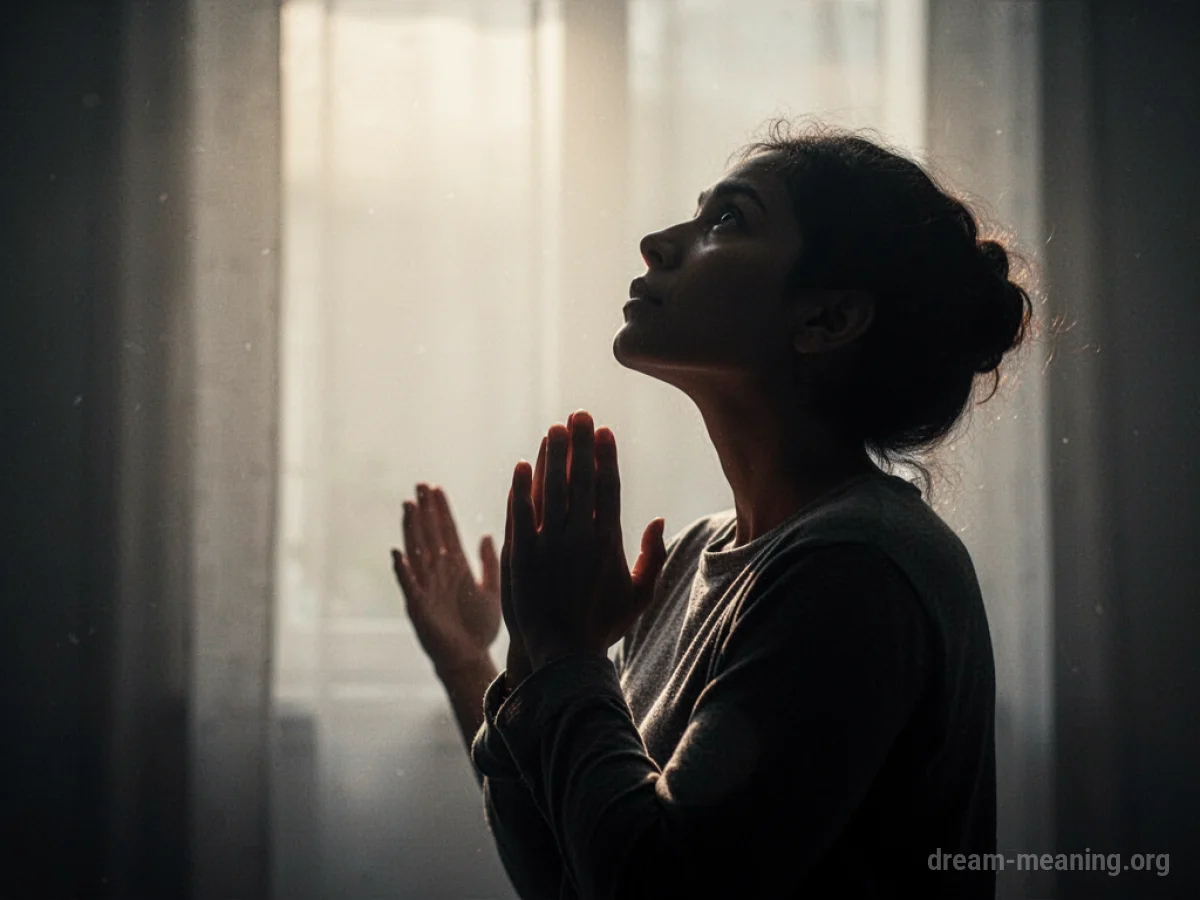 Silhouette of a person praying with hands clasped.
