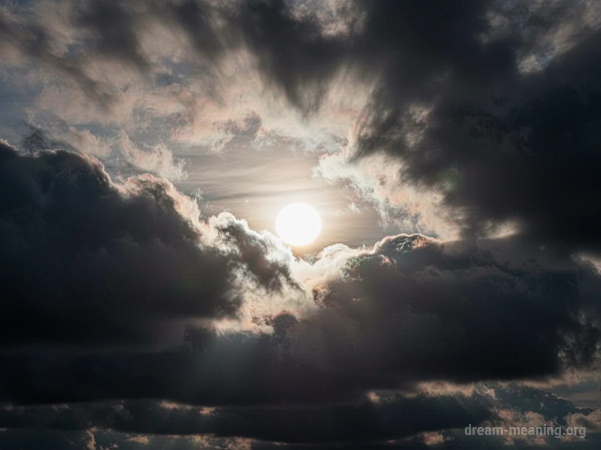 A sun partially covered by dark clouds.