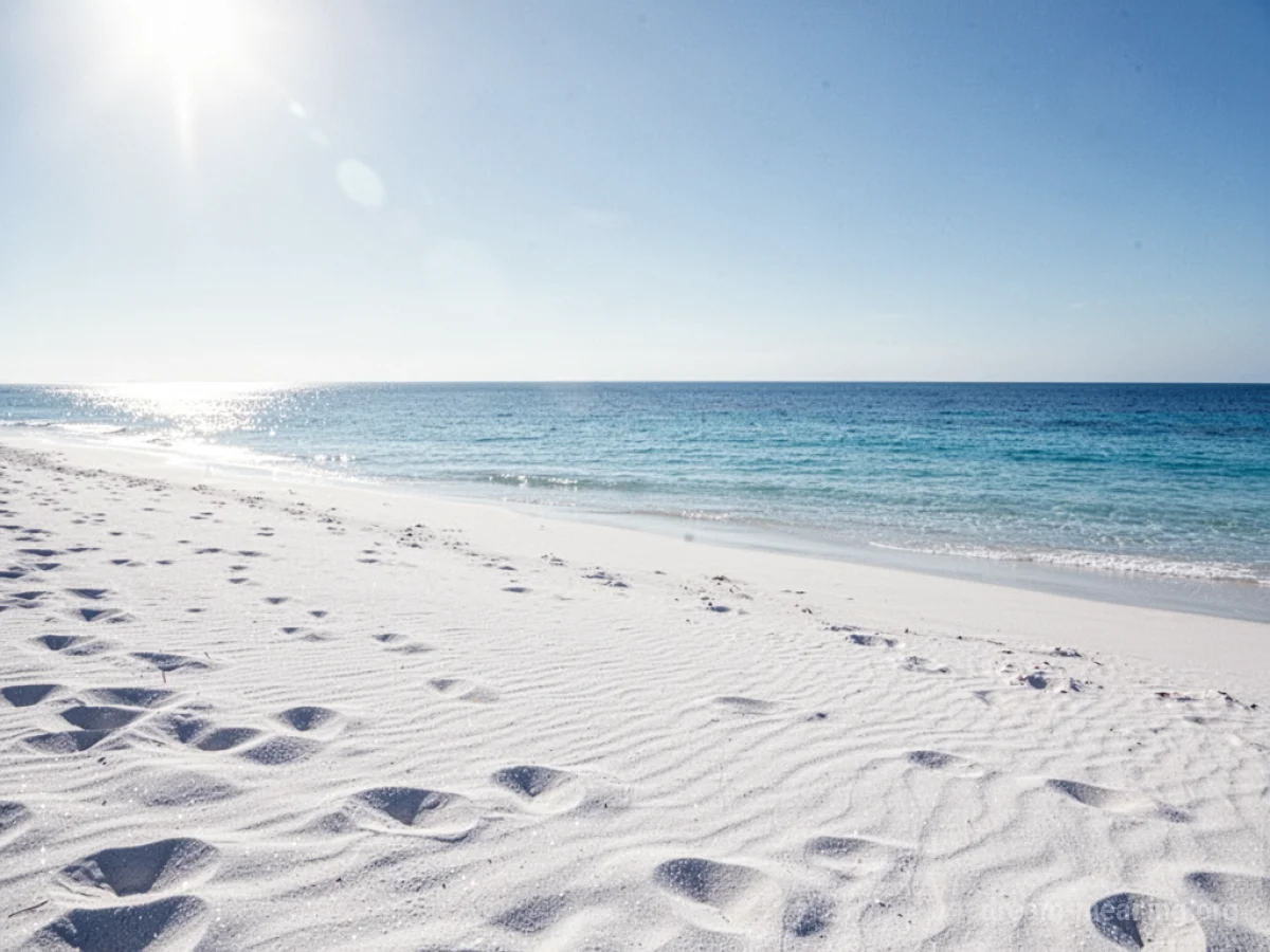 Vast white sand beach meeting the ocean.